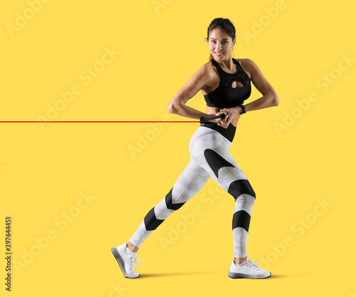 Fitness woman performs exercises with resistance band