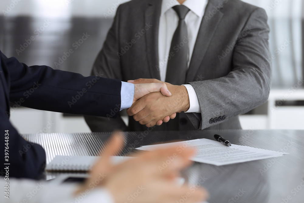 Unknown business people are shaking hands after contract signing in modern office, close-up. Handshake as successful negotiation ending Unknown business people are shaking hands after contract signing in modern office, close-up. Handshake as successful negotiation ending