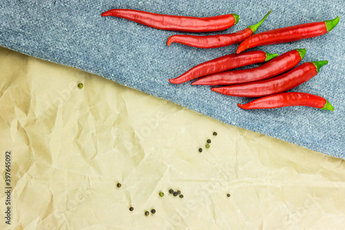 red chili pods are located on the fabric plane peppers. top view © kristina