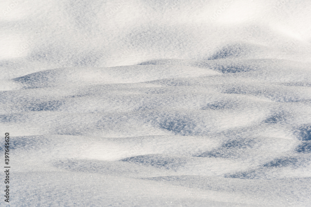 Smooth snow drifts on sunny winter day. Deep and high snow drifts illuminated by sunlight and being in shadow Smooth snow drifts on sunny winter day. Deep and high snow drifts illuminated by sunlight and being in shadow