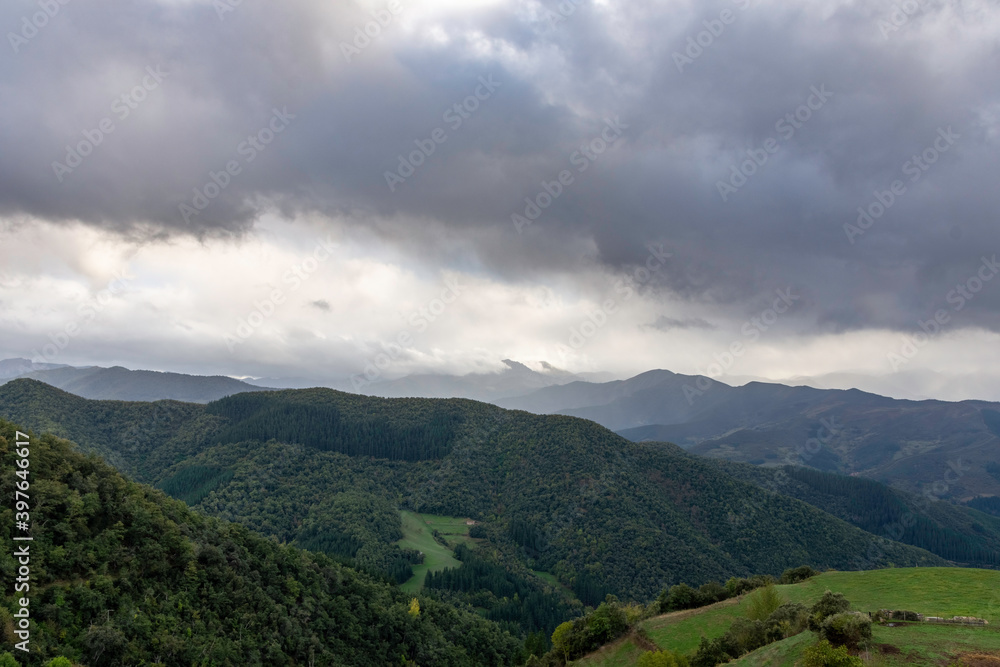 green mountains landscape with gray clouds, dramatic sky