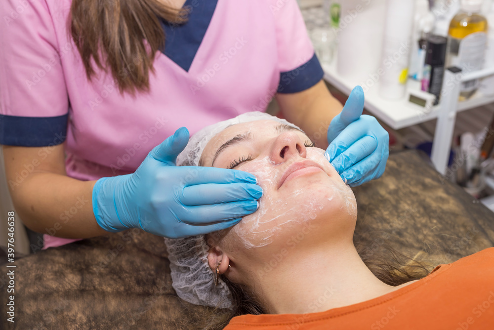 Beautician with gloves washes the face of a young woman. Removal of cosmetics. Beautician with gloves washes the face of a young woman. Removal of cosmetics.
