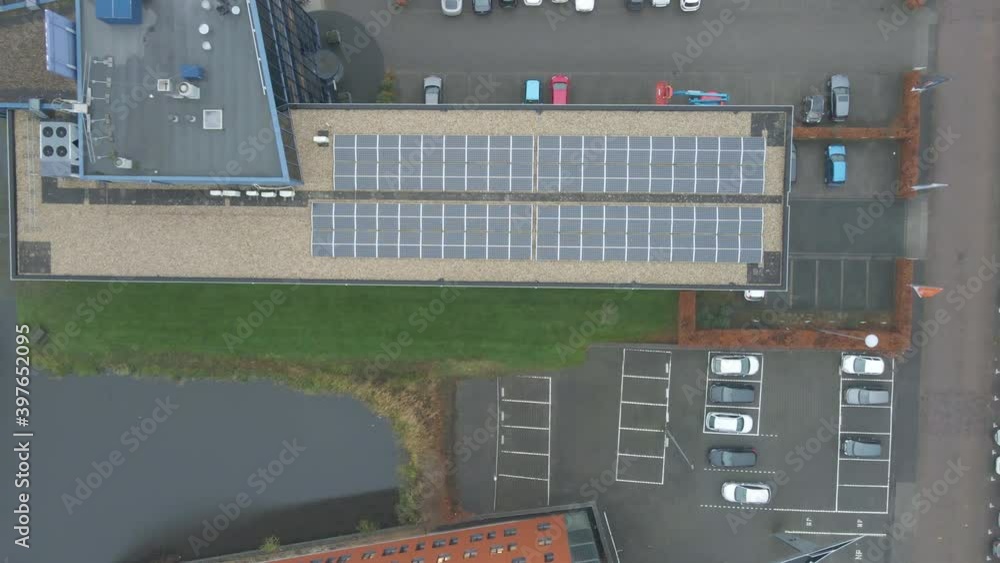 Top down aerial of solar panels on office building rooftop - drone setting down Top down aerial of solar panels on office building rooftop - drone setting down