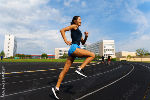 Athlete runner running on athletic track training her cardio.