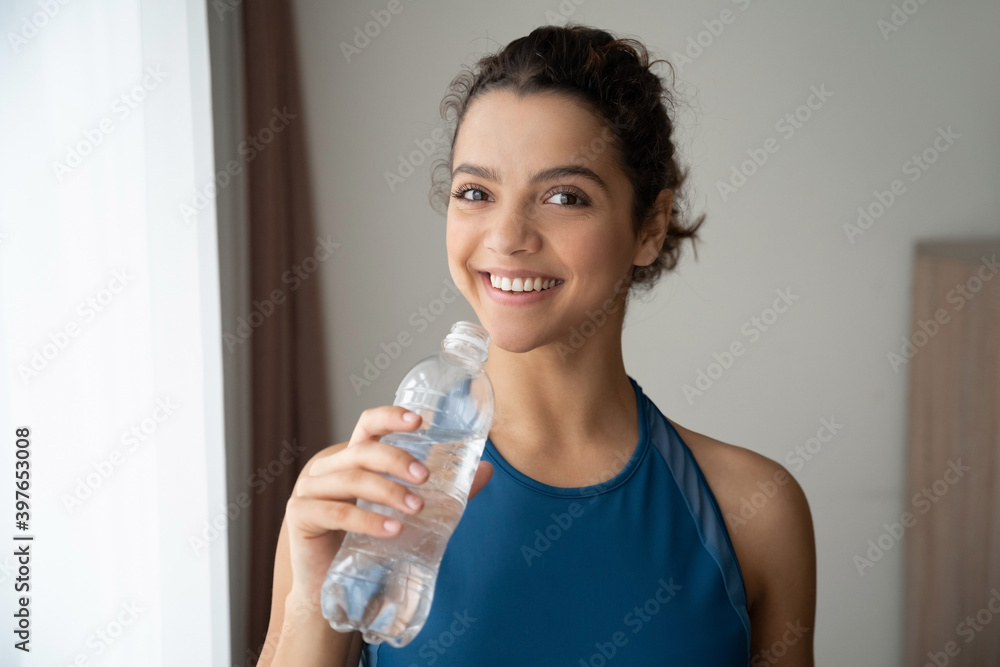 Close-up portrait of beautiful smiling young fit woman drinking water at home. Close-up portrait of beautiful smiling young fit woman drinking water at home.