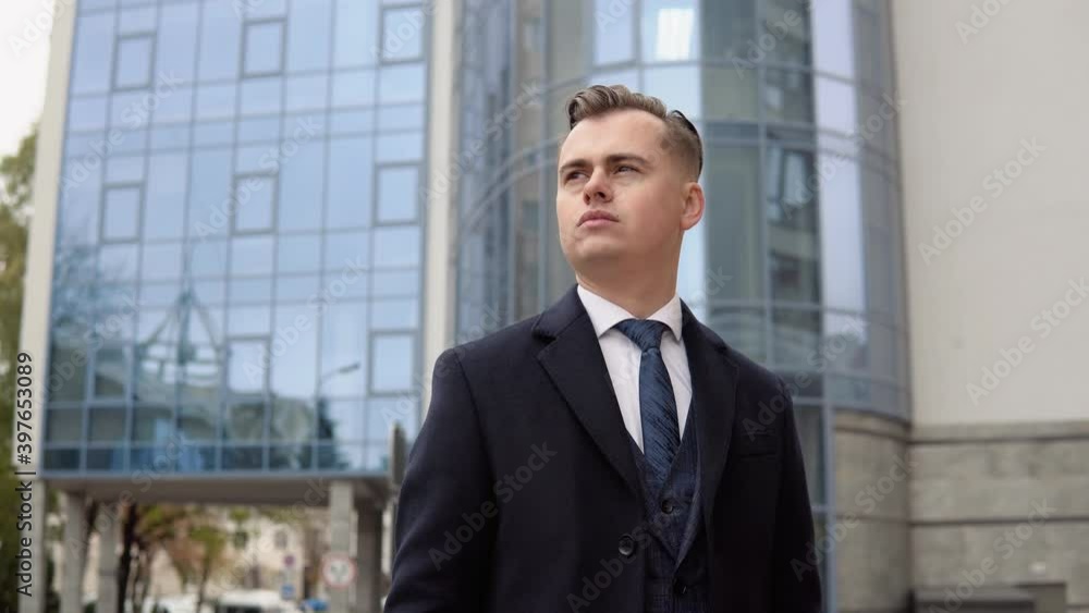 Stylish male businessman in blue jacket and coat near office center waiting for business meeting Stylish male businessman in blue jacket and coat near office center waiting for business meeting