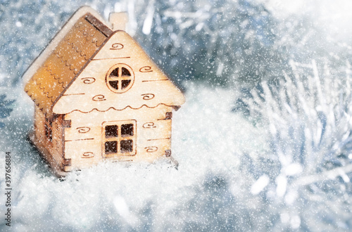 Christmas composition. New year toy wooden house in snow  snowflakes background. New year decorations