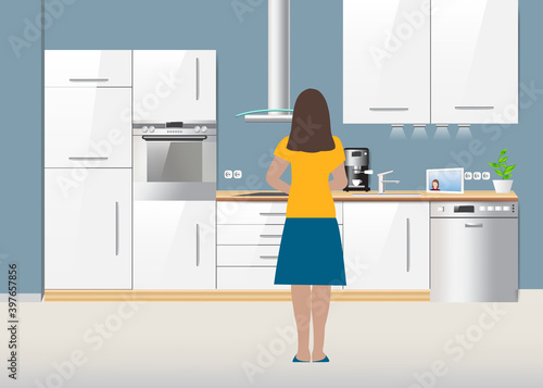 Woman is cooking with her back turned in the kitchen while communicating with another woman online via a tablet. 