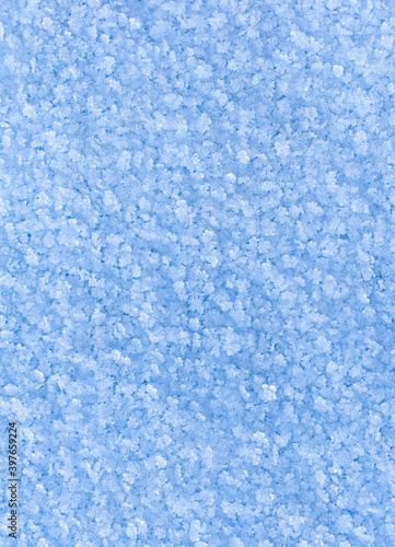 Winter snowy vertical background with snow crystals. Copy space, textured frozen surface, natural background, wallpaper