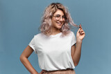 Youth, beauty, style and fashion concept. Portrait of cute playful young woman with pinkish hair and nose ring posing isolated in round glasses, looking at camera with charming flirty smile