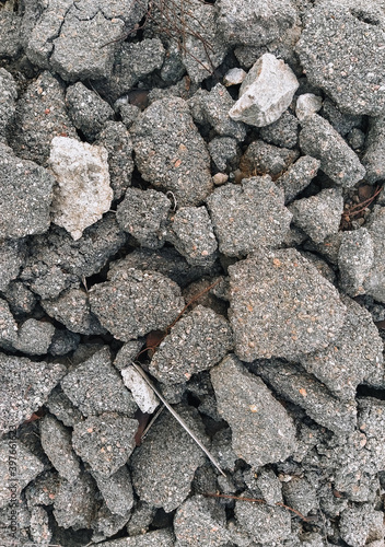 Texture, the background of the destroyed, cracked in pieces of gray asphalt.
