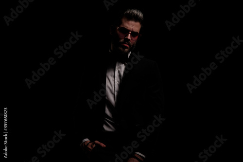 arrogant fashion guy in black velvet tuxedo holding hands in pockets