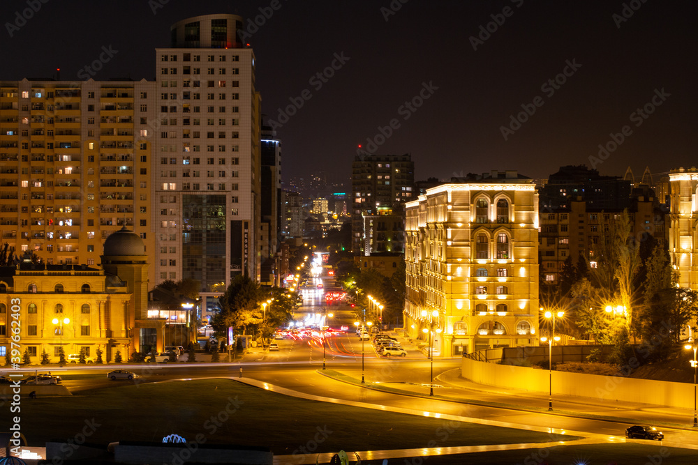 Night view of the center of Baku. The movement of cars through the night city. Skyscrapers, high-rise buildings and automobile interchanges. Republic of Azerbaijan