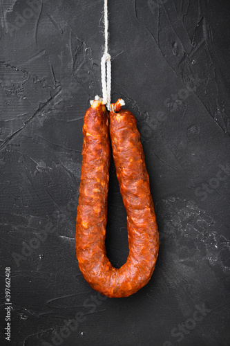 Traditional chorizo sausages on black background, topview