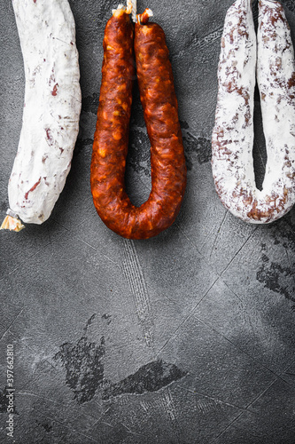Spanish salami from a rack at market on grey background with space for text
