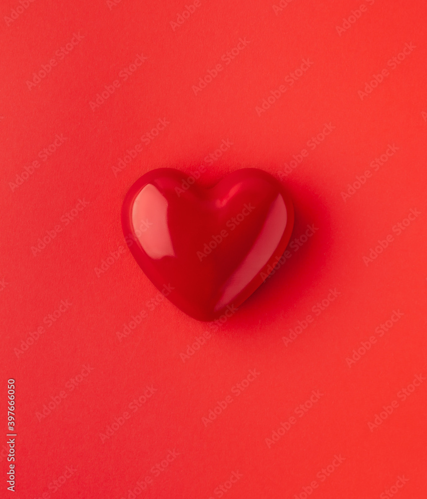 Valentine's day or Wedding romantic concept. Red heart on red background. Top view, copy space.