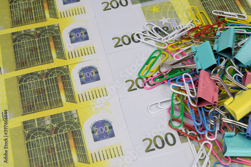 There is a stack of colored paper clips and clips on the 200 euro banknotes