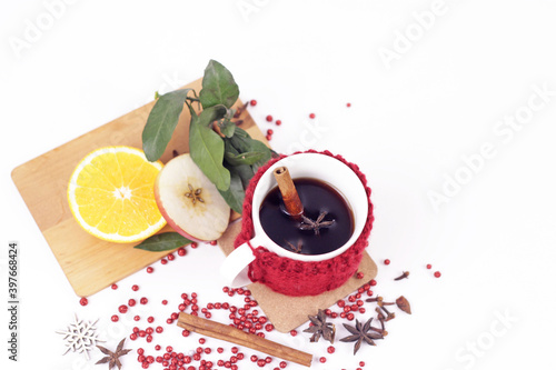 Delicious mulled wine and ingrediets on white background.Hot red beverage in cozy mug with christmas spices, anise, orange and apple slice, cinnamon sticks.Holiday christmas hygge and homely concept photo