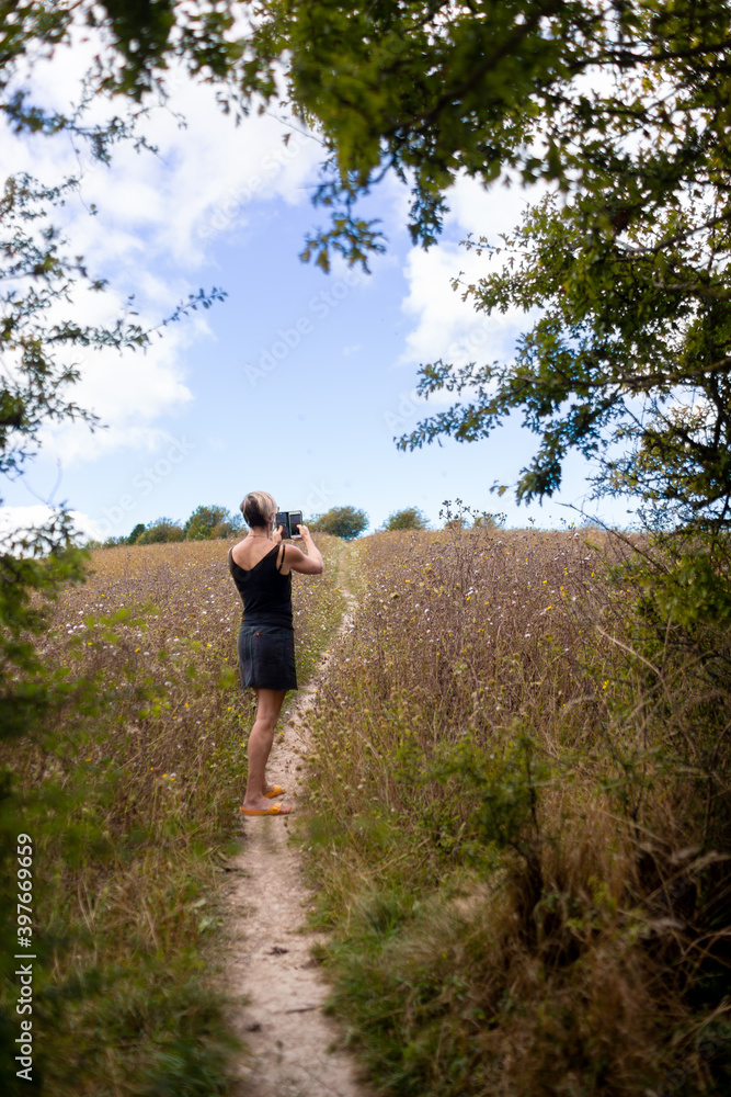 woman in field taking picture