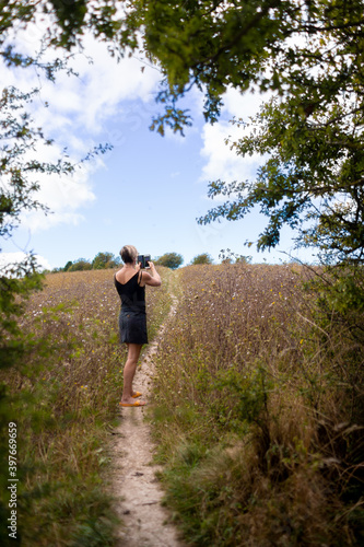 woman in field taking picture