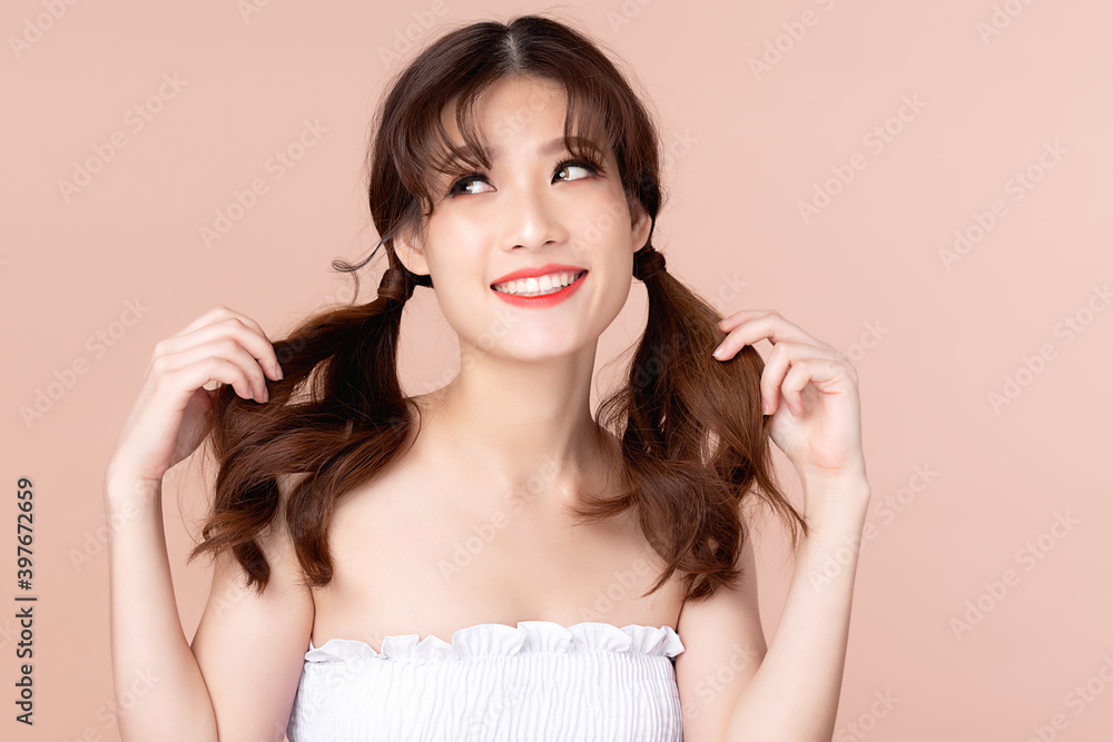 Happy young asian woman has two pigtails smiles and showing OK sign, Presenting your product. Clean and fresh skin with positive emotional, Facial treatment, isolated on beige background. Happy young asian woman has two pigtails smiles and showing OK sign, Presenting your product. Clean and fresh skin with positive emotional, Facial treatment, isolated on beige background.