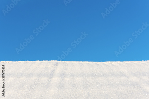 White snow and blue sky as winter background, copy space available