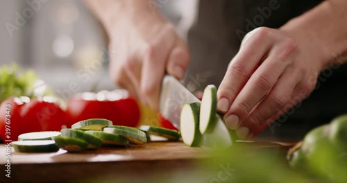 Chef using a knife cutting fresh raw sqaush. Cooker at home making a healthy vegetable meal, cutting up veggies - food and drink 4k footage photo