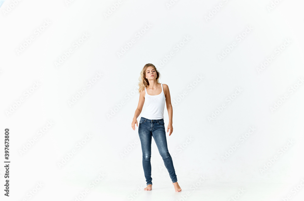 woman in full growth on a light background in jeans and a t-shirt model woman in full growth on a light background in jeans and a t-shirt model