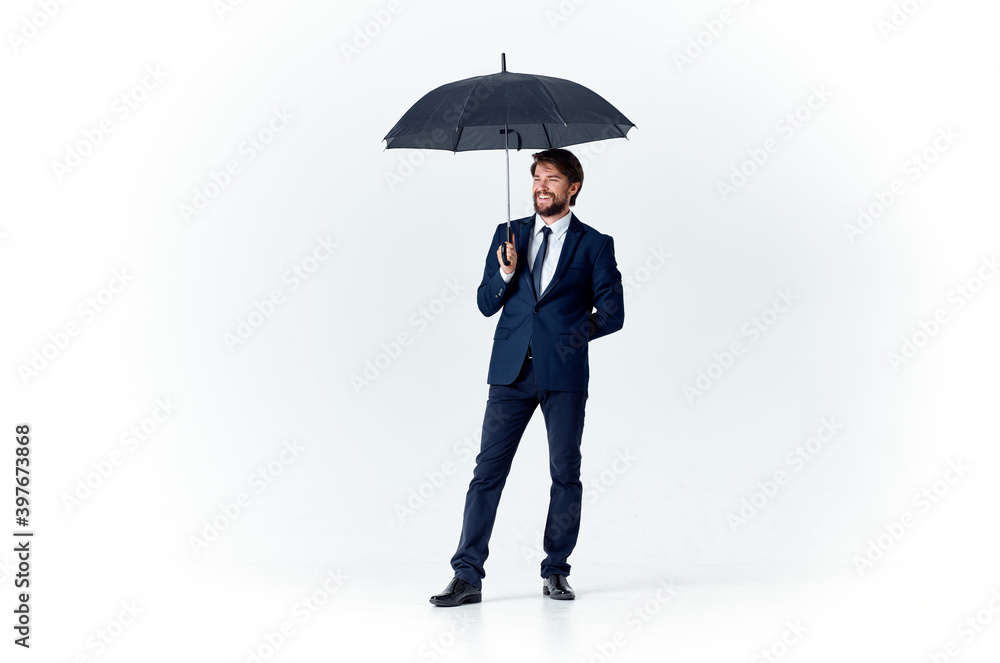 elegant gentleman with a dark umbrella on a light background and a classic suit elegant gentleman with a dark umbrella on a light background and a classic suit