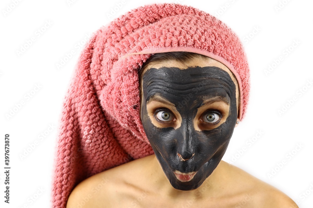 girl with a clay cosmetic mask on her face makes faces. Spa procedures. Isolated on white background girl with a clay cosmetic mask on her face makes faces. Spa procedures. Isolated on white background
