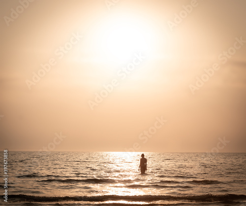 woman on sunset shallow sea