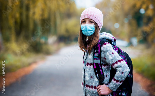 Schoolgirl with medical mask in Covid-19 time. Healthcare, medical concept