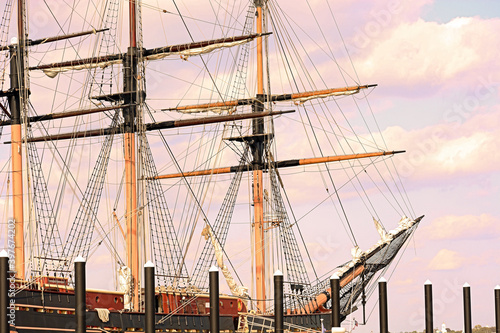 Three masted tall ship docked at a wharf photo