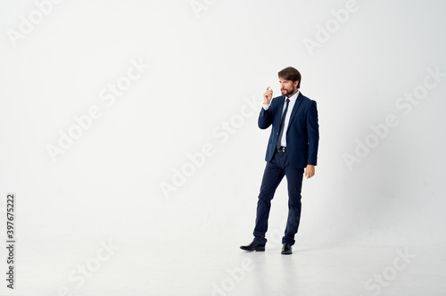 a business man in a classic suit stands in the middle of a room indoors