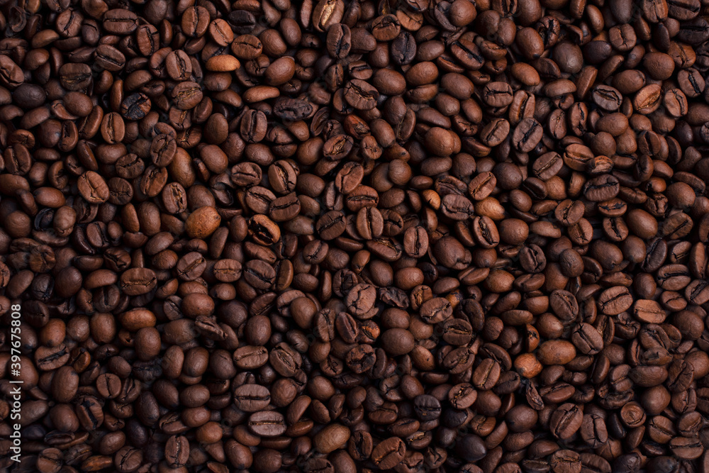 Scattered piles of roasted arabica coffee beans top view in daylight Scattered piles of roasted arabica coffee beans top view in daylight