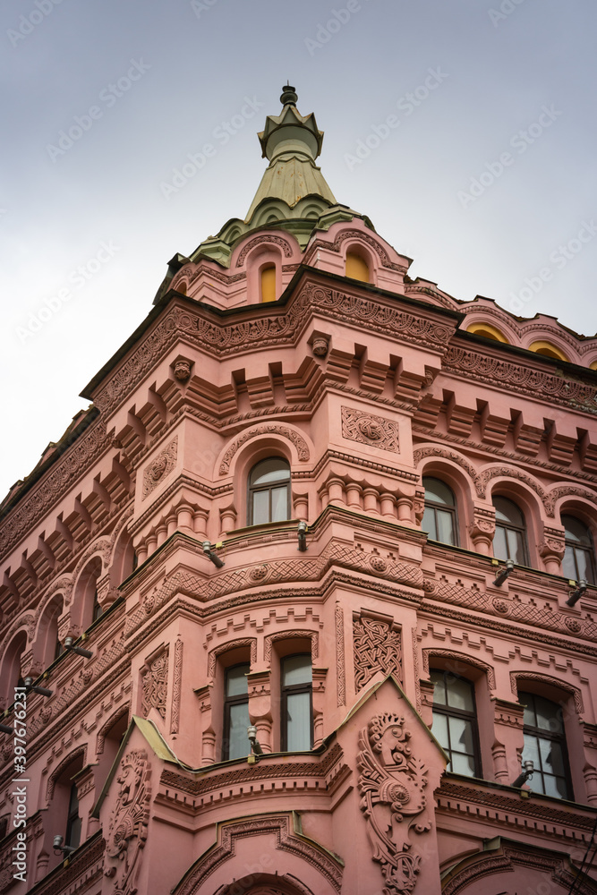 Pink and red historical building Bazin House in Russian style. Decorative facade with turrets, windows, stucco. Saint-Petersburg, Russia