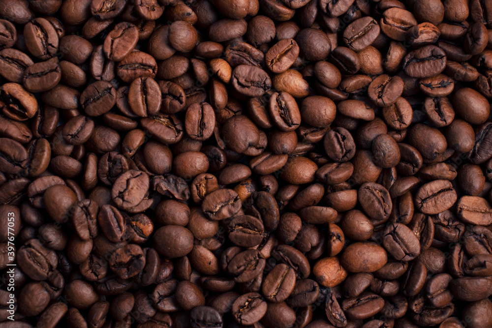 Scattered piles of roasted arabica coffee beans top view close up in daylight Scattered piles of roasted arabica coffee beans top view close up in daylight