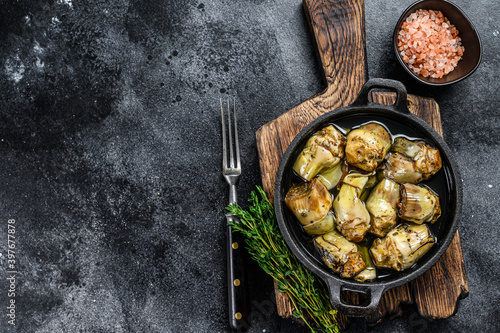 Fotografia Canned artichokes in olive oil on a rustic wooden kitchen table