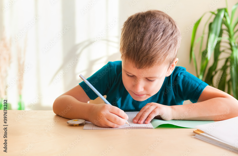 7 years old child boy doing math exercise while sitting at desk. Concept of homeschooling 7 years old child boy doing math exercise while sitting at desk. Concept of homeschooling