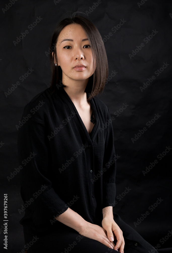 Beautiful korean woman dressed in black dress sitting on chair studio portrait. Beautiful korean woman dressed in black dress sitting on chair studio portrait.