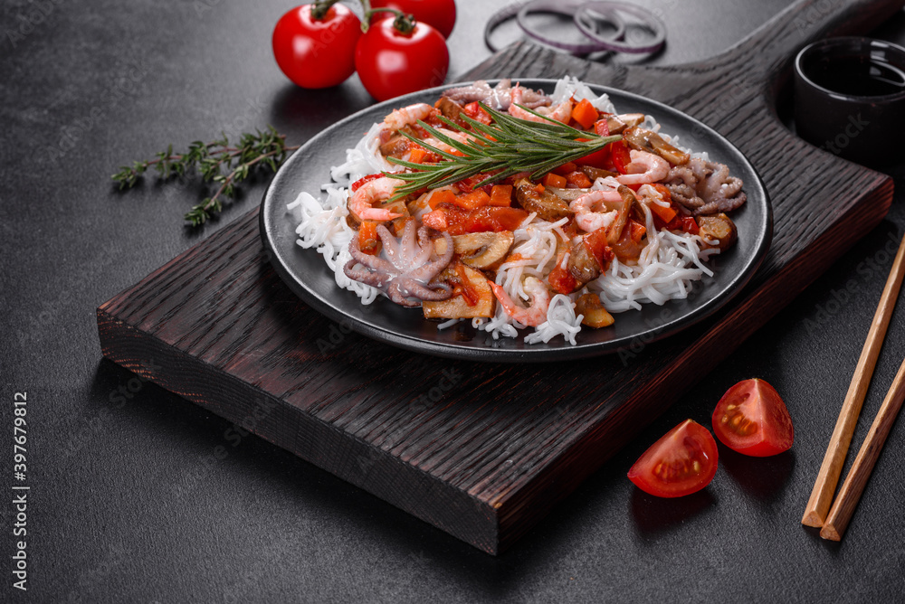 Tasty rice noodles with tomato, red pepper, mushrooms and seafood
