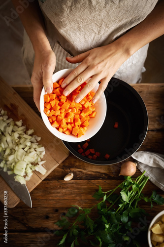 Woman in the kitchen preparing homemade food, female hands working with fresh vegetables