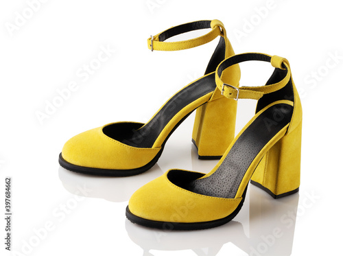 A pair of yellow female suede shoes on a white background.