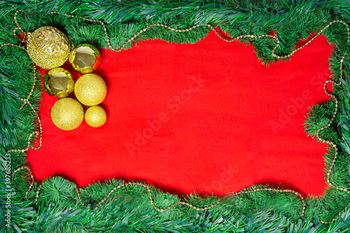 cartão natalino com moldura de guirlanda verde com fundo vermelho e bolar de natal douradas photo