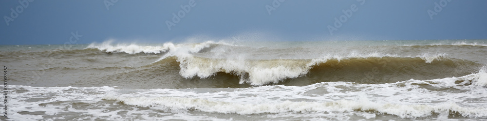 Fototapeta premium Foamy waves in the stormy Baltic sea in full sun, luminous glare.