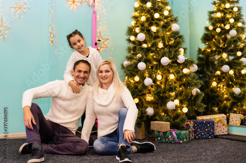 happy young family with one child holding christmas gift and smiling at camera © Angelov
