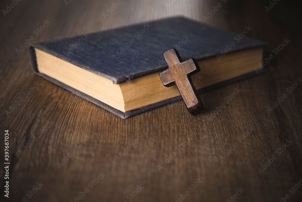 cross on the Bible on a wooden background