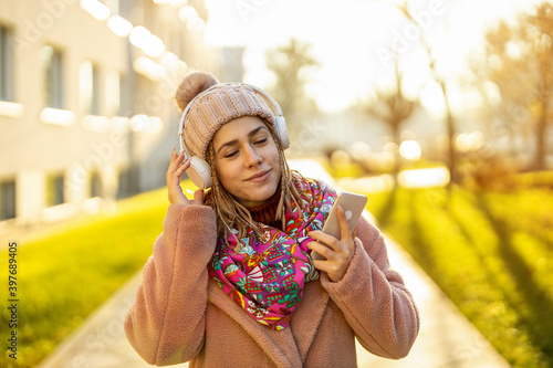 Happy young woman with headphones and cell phone 