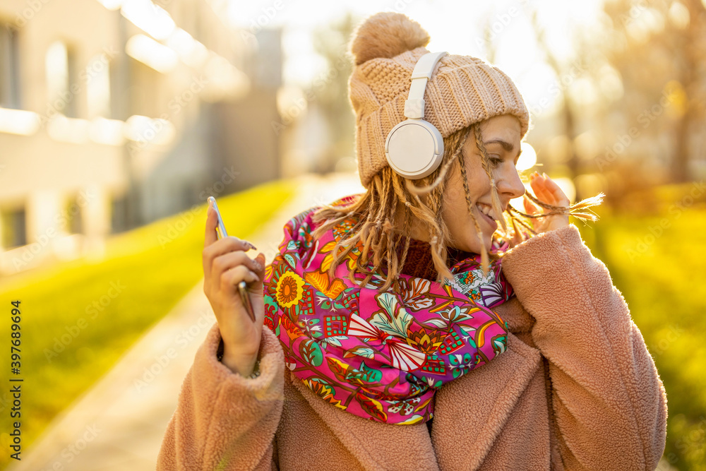 Happy young woman with headphones and cell phone
