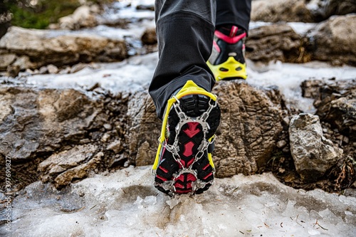 Shoes with crampons on the mountain trail in winter, climbing, adventure. photo
